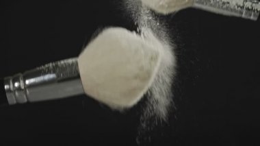 Toz bulutu iki makyaj fırçaları tozu slo-mo ile yakın çekim