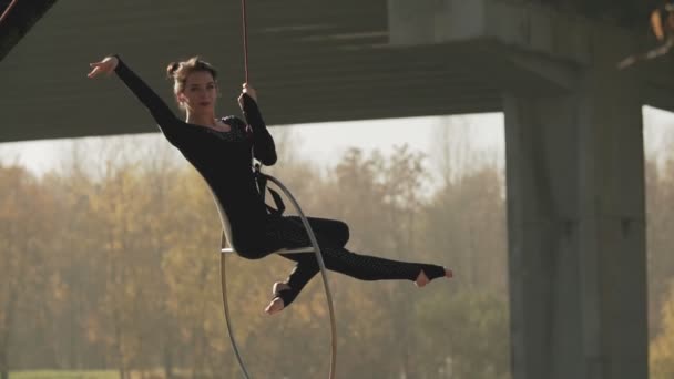 Flexibel brunett med nakna fötter hänger i ringen för luftakrobatik i slo-mo — Stockvideo