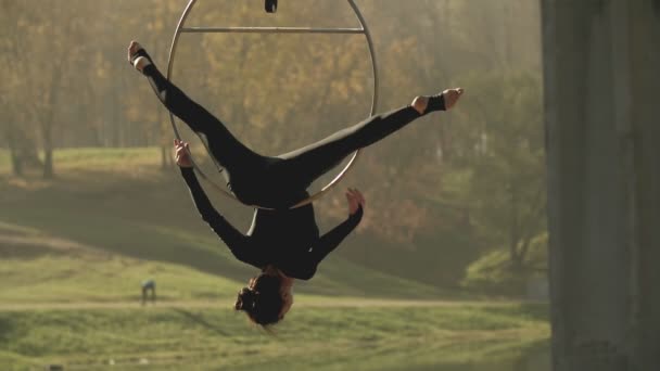 Air gymnastique femme effectue des tours d'acrobatie sur cerceau aérien au ralenti — Video