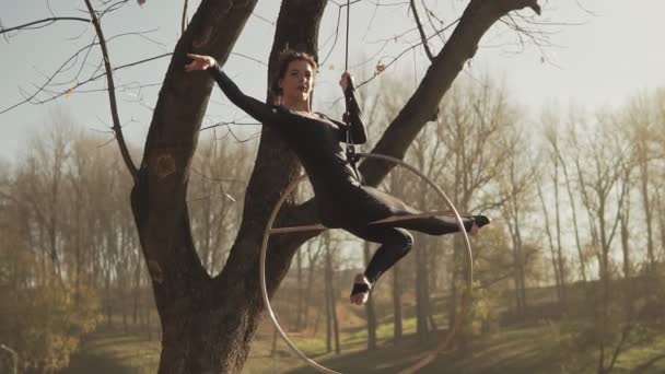 Mujer gimnasia de aire realiza acrobacias trucos en aro aéreo al amanecer — Vídeo de stock