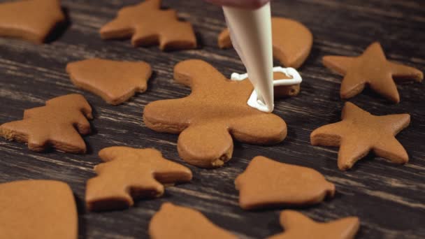 Dekoration process av julkakor. Närbild garnering pepparkakor män — Stockvideo