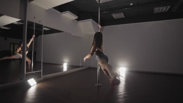 Ung sexig kvinna pole dancing på mörka studio med spegel i slow motion — Stockvideo