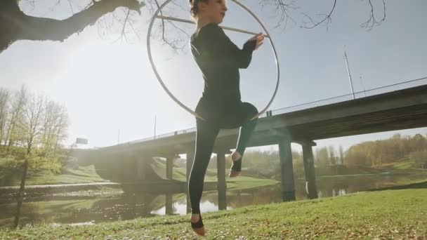 Flexibla gymnastik kvinna utför akrobatik tricks på aerial hoop utomhus — Stockvideo