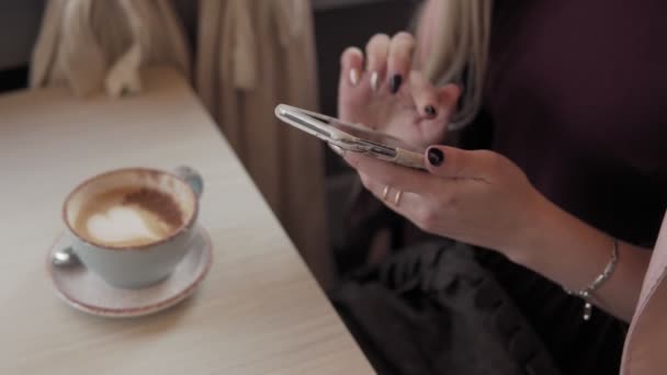 Schöne Mädchen Nachrichten und Kaffee trinken in der Stadt Café während ihrer Pause — Stockvideo