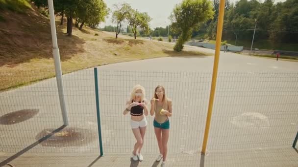 Chicas felices en gafas de sol que se divierten haciendo burbujas al aire libre — Vídeos de Stock