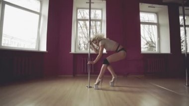 Pole Dance. Genç güzel kadın seksi dans gerçekleştirin. İnce kız dans