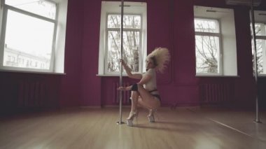 Egzotik dans. Sarışın kadının poledance Studio yapması.