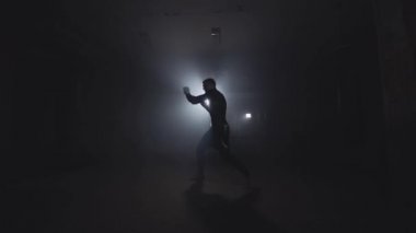 Boksör dumanlı Studio'da eğitim. Koyu spor salonunda boks sporcu