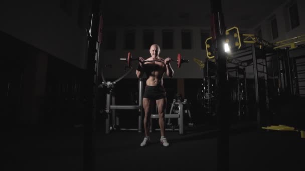 El levantador de pesas eleva la barra a los bíceps de entrenamiento. Culturista con barra en gimnasio — Vídeos de Stock