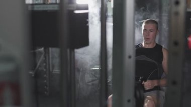 Adam egzersiz kopya alanı sol ile koyu spor salonunda fitness makinedeki