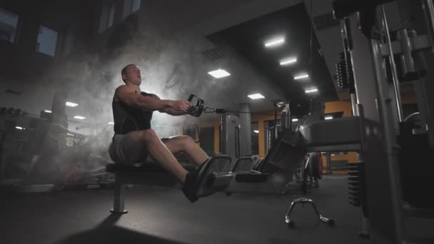 Sehr leistungsstarke athletische Kerl Bodybuilder führen Übung mit Fitnessgeräten in Innenräumen. — Stockvideo