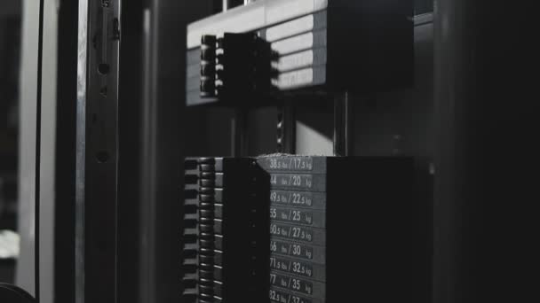 Caída de peso en la máquina de bloques y nube de levantamiento de polvo en el gimnasio oscuro en slomo — Vídeo de stock