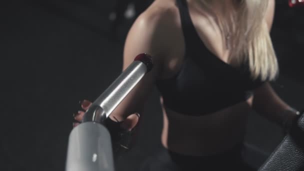 Close up de menina loira em terno esporte treinando seus braços em simulador de esportes — Vídeo de Stock