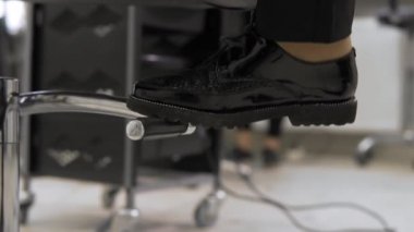 Berber koltuğu. Kuaför koltuğu düzenleyen yükseklik berber. Kadın ayakları