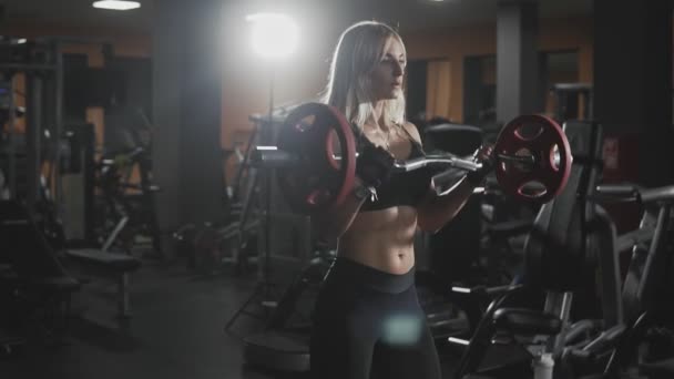 Chica en ropa deportiva negro entrena bíceps de la mano en cámara lenta — Vídeos de Stock