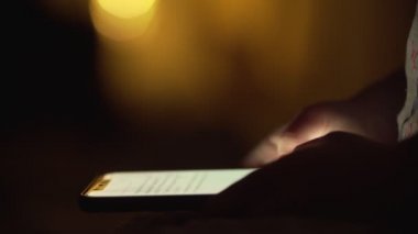 Yakın çekim çocuk elleri ile smartphone kapalı bir kadeh. Kız yazarak mesaj