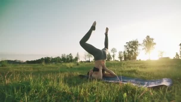 Mujer delgada practicando yoga por la mañana. Chica morena haciendo movimientos de yoga — Vídeos de Stock