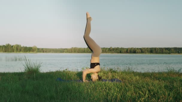 Ładna dziewczyna robi joga odkryty o wschodzie słońca. Dziewczynka fitness szkolenia rano — Wideo stockowe