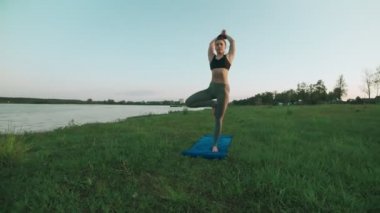 Güzel genç kadın mavi yoga mat sessiz sahne sabah yoga yaparken