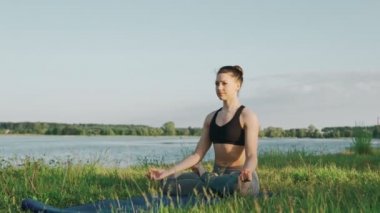 Gölde sabah yoga yaparken kadın. Gündoğumu, lotus pozisyonda güzel kız