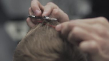 Berber Kuaför kesim saç yakın çekim. Kuaför saç makas ile keser.