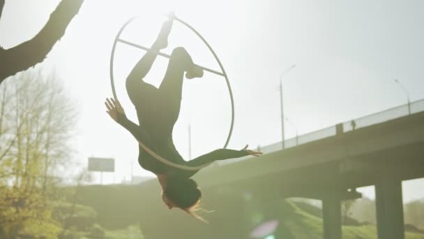 Vrouw doen sommige acrobatische elementen op luchtfoto hoepel buitenshuis — Stockvideo