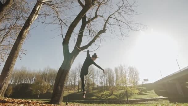 Silhouette de femme faisant quelques éléments acrobatiques sur cerceau aérien à l'extérieur — Video