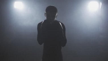 Ağır çekimde düşük ışık salonunda eğitim kick boks şampiyonu. Kamera boks sporcu