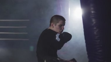 Muay Tay savaşçı kum torbası ile eğitim. Ağır çekimde Delme kick boks şampiyonu