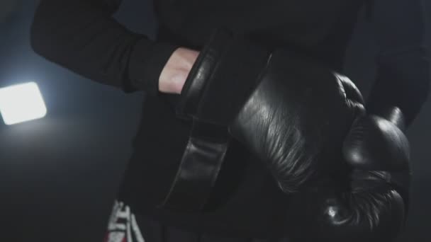 Gros plan du boxeur portant des gants de boxe sur fond noir au ralenti — Video