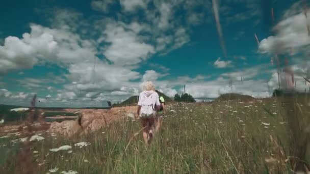 Deux belles filles voyageant avec des sacs à dos. Randonneurs marchant à la carrière avec lac — Video