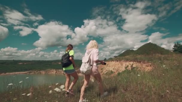 Wandelaars lopen langs de groeve met meer in slow motion. Travel concept — Stockvideo