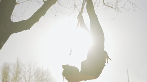 Mujer gimnasia de aire realiza acrobacias trucos en aro aéreo al amanecer — Vídeo de stock