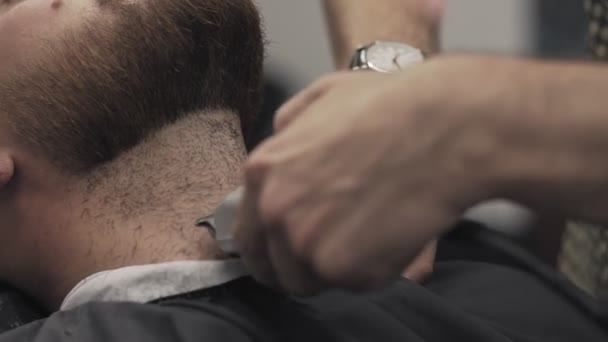 Barber shaving beard with electric razor in male salon. Barber trimming beard — Stock Video