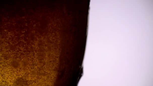 Öl hälls i glas på vit bakgrund i slow motion med kopierings utrymme till höger — Stockvideo