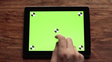 Ahşap masa üzerinde yeşil ekran ile tablet kullanma. Mock-up kullanımı Için harika