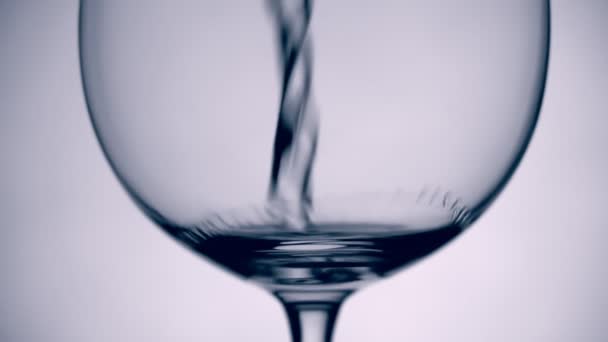 Eau à mouvement lent versée dans du verre sur fond blanc 
