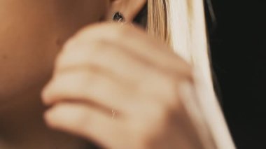 Genç kadın güzel küpe koyar. Yakın çekim