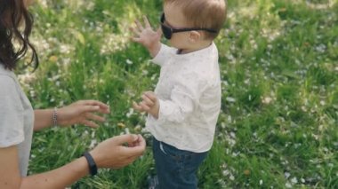 Genç Anne ve oğlu açık havada güneş gözlüğü ile oynuyor. Annelik kavramı