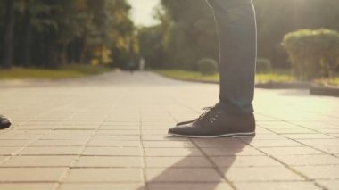 Ayak parmağında kadın var. Yüz yok. Parkta birkaç stand. Yakın çekim