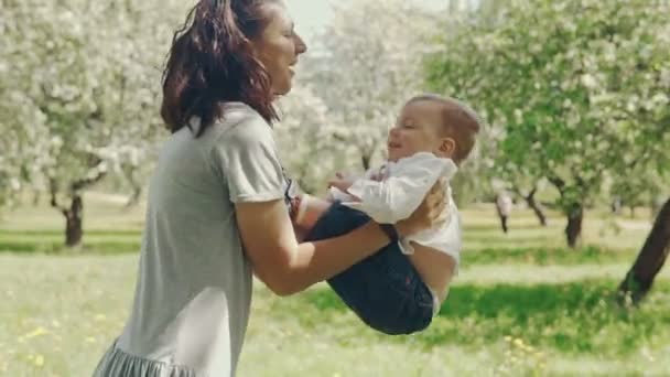 Mamá mostrando amor y afecto a su hijo. Joven madre e hijo jugando al aire libre — Vídeos de Stock
