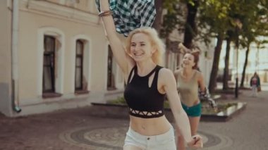 Sokakta koşan güzel hipster kadınlılar. Şort gülümseyen kızlar eğlenmek