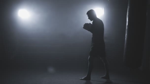 Boxeador de patadas en gimnasio de poca luz en slo-mo. Boxeo deportivo en gimnasio ahumado — Vídeo de stock