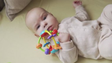 El oyuncak ile kamera bakarak sevimli küçük bebek üst görünümü