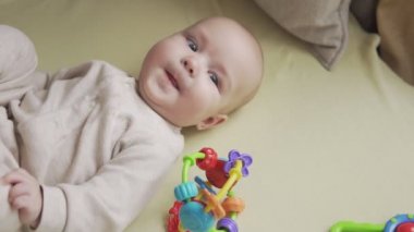 Yatakta bebek luying yakın yukarı ve kamera gülümsüyor. Çocukluk konsepti