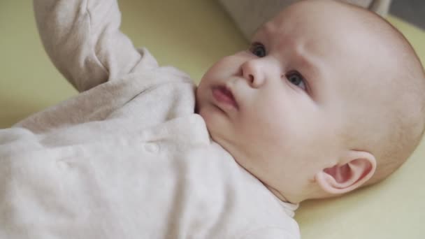 Kis baba fiú feküdt az ágyon. A gyermekgondozás és a szülői szeretet fogalma — Stock videók