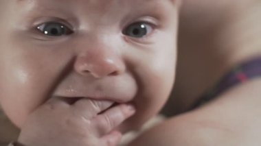 Gülümsüyor iken babys yüz yakın. Anne elleri mutlu çocuk