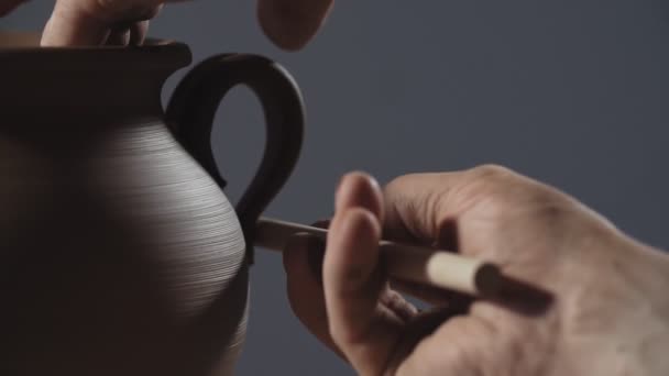 Man handen maken van klei product. Potter maken kruik handvat van klei in slow motion. — Stockvideo