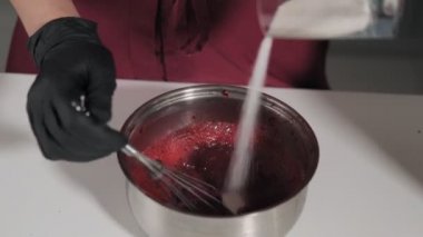 Tatlı için dolgu yapma süreci. Kiraz ve şeker kütlesi karıştırılır