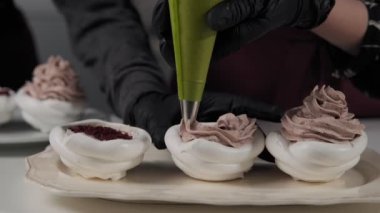 Şekerlemeci parti için kek yapıyor. Krem ile Pavlova Dekorasyon çöl